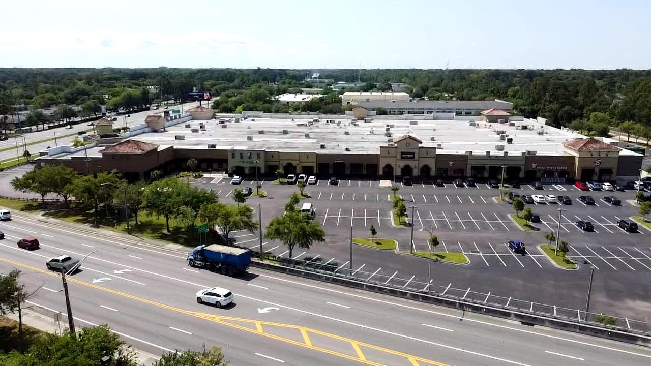 An aerial view of a one-story retail center and intersection.