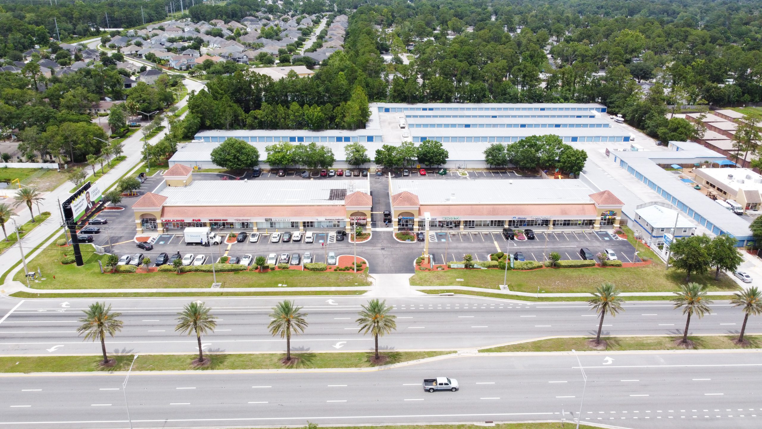 An aerial view of a one story retail center and road.