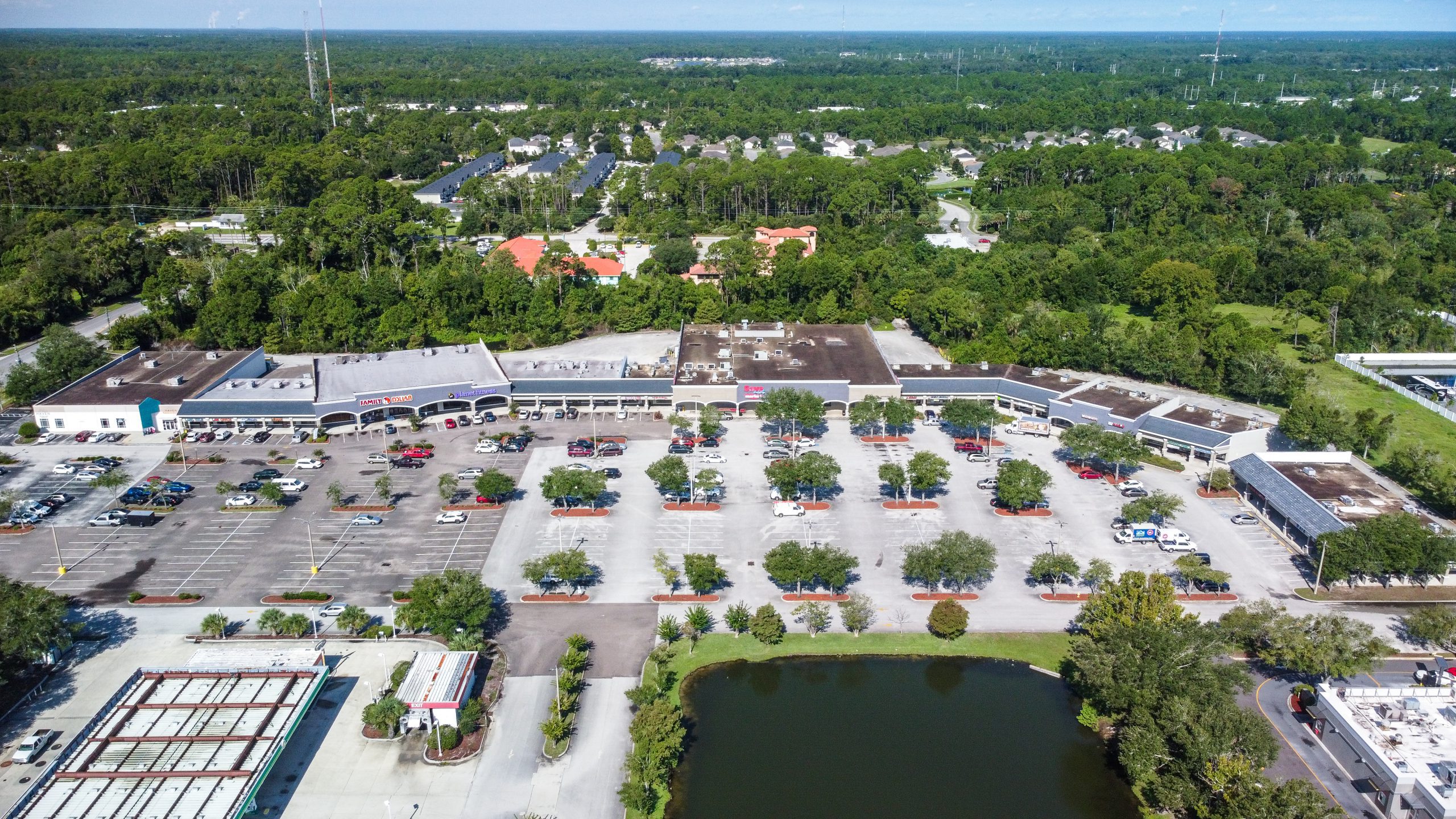 An aerial view of a parking lot and retail center.