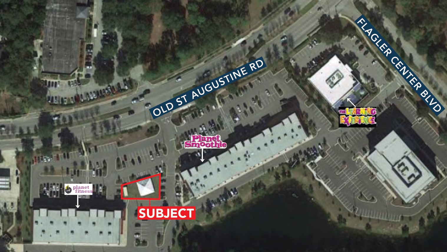 An aerial view depicting an out-parcel for sale and the surrounding roads and businesses.