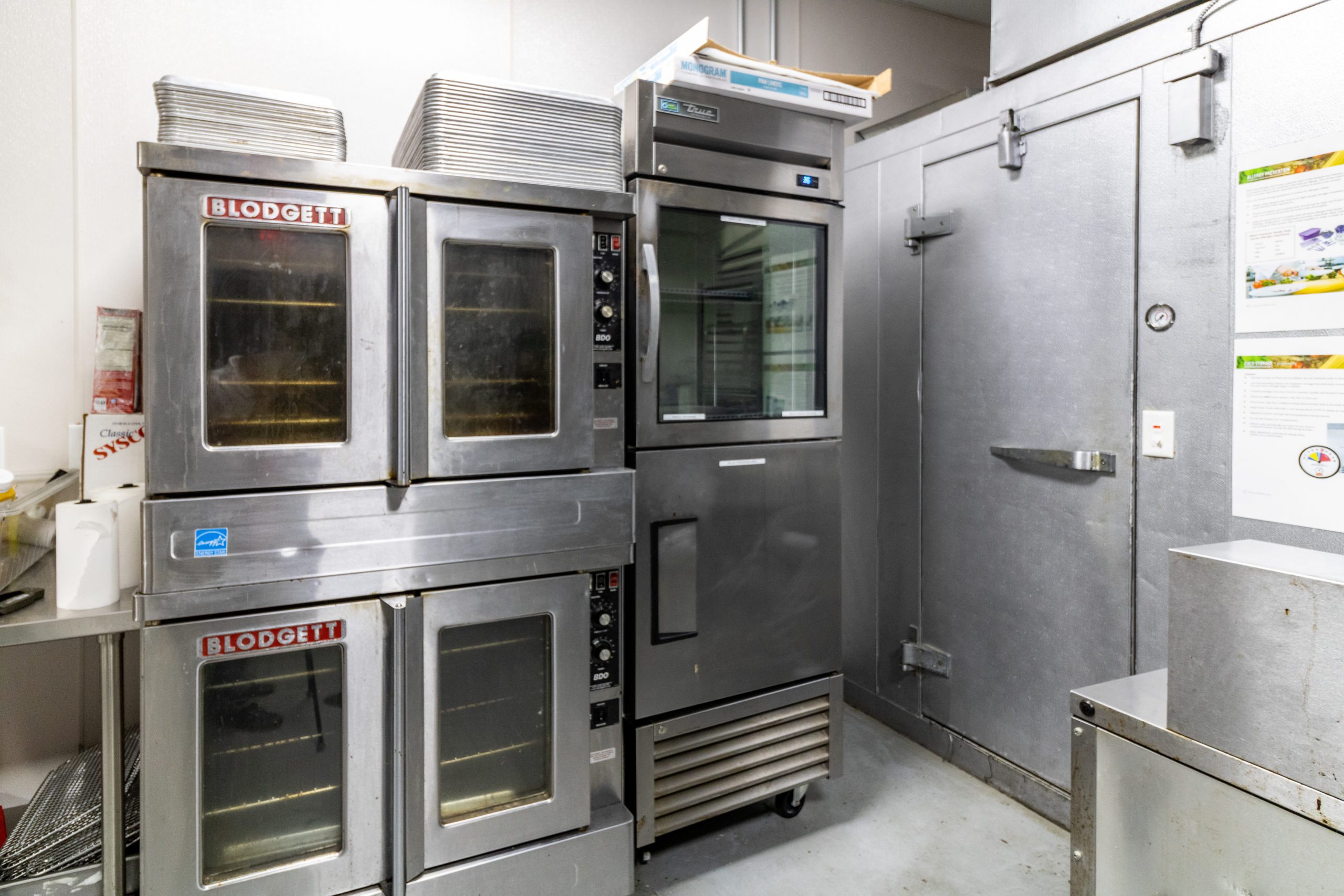Commercial ovens and entrance to a walk-in cooler/freezer.