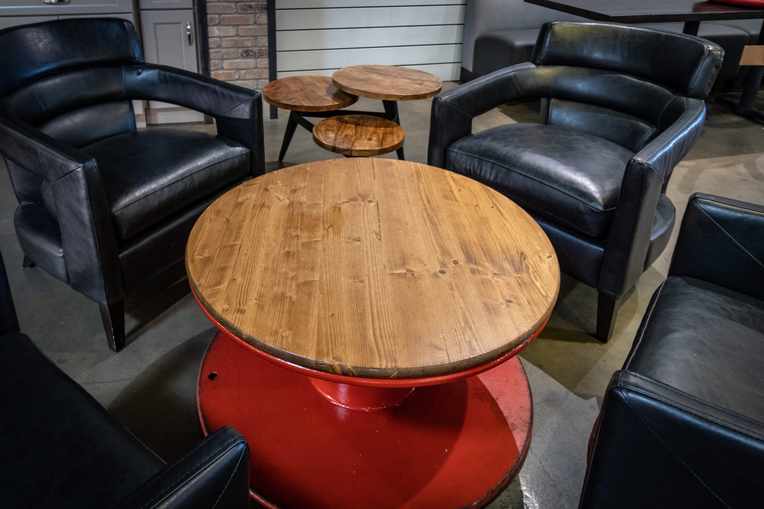 Black leather chairs with surrounding industrial style tables.